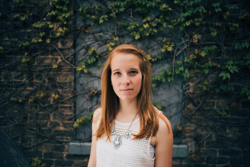 Young woman in front of an ivy wall