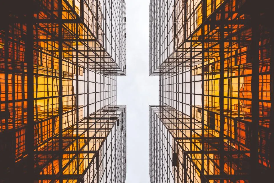 Looking up between glass skyscrapers