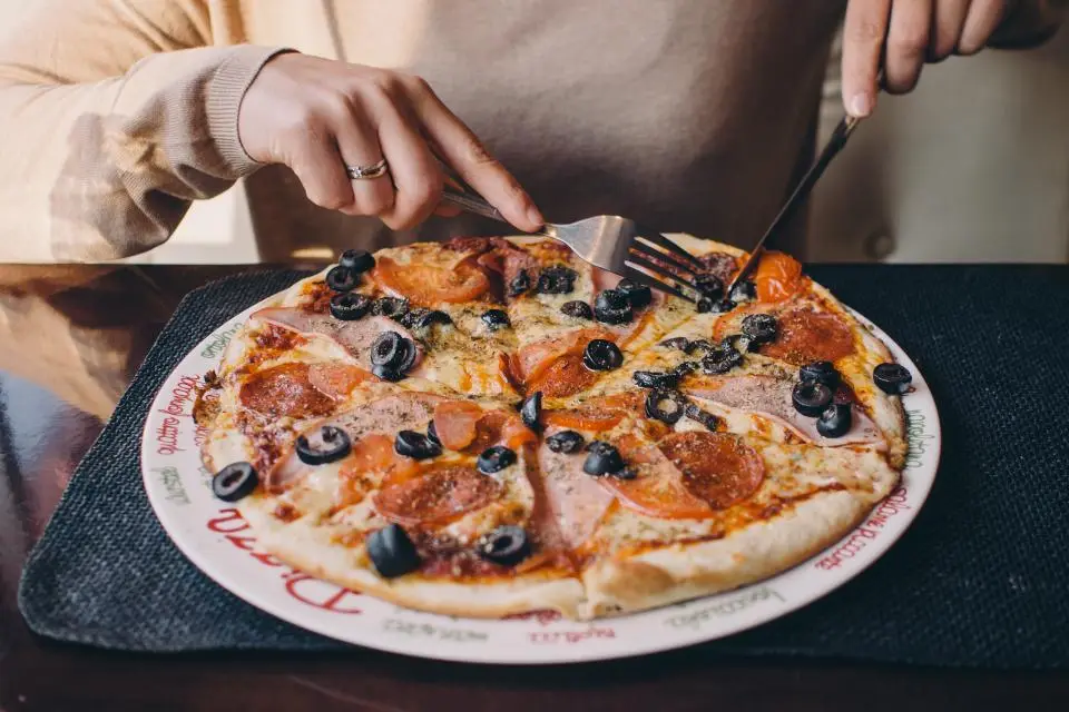 Cutting a cheese pizza